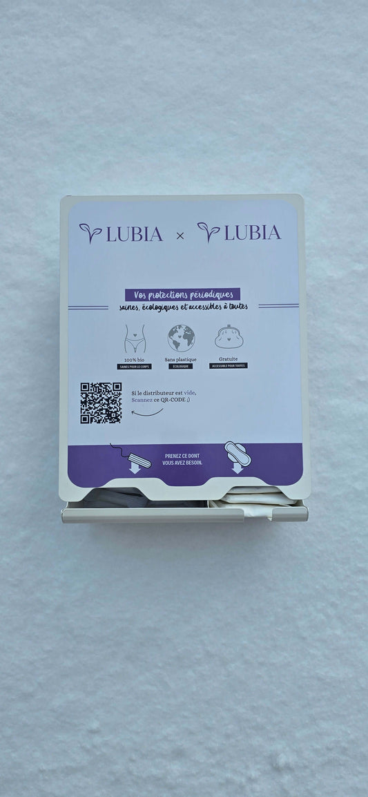 Distributeur serviette hygiénique à installer, avec informations et instructions, sur un mur blanc.